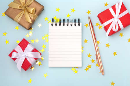 Christmas wish list with gift boxes on blue background with star glitter, flat layの写真素材
