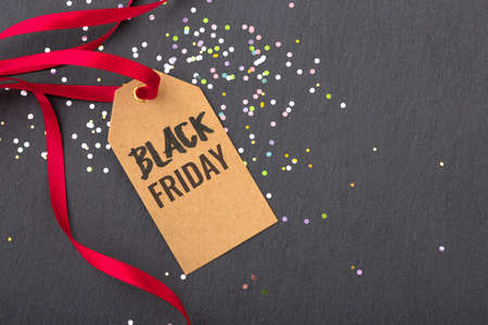 Black friday sale tag with red ribbon on glitter dark stone backgroundの写真素材