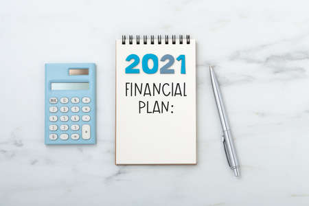 2021 Financial planning text on notebook with calculator and penの写真素材