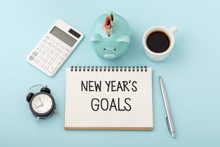 Financial goals for new year concept with piggy bank and calculator on blue background