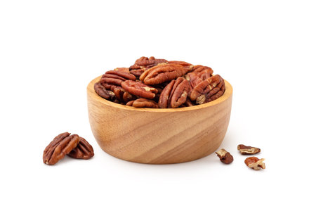 Pecans in wood bowl isolated on white background