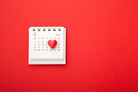 Valentines day background with love heart on calendar on red background, top viewの写真素材