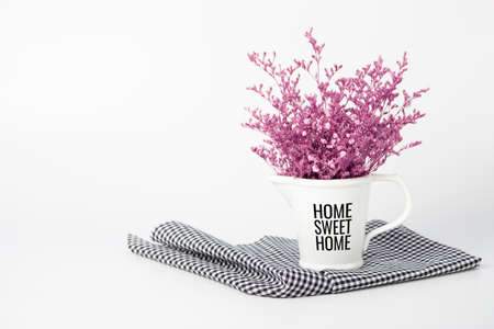 Pink dry flower in decorative vase on plaid cloth on white backgroundの写真素材