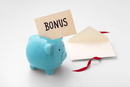 Bonus with blue piggy bank and envelope with red ribbon, saving extra money conceptの写真素材