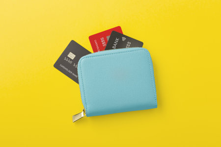 Wallet with credit card on yellow background, flat lay