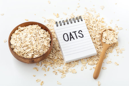 Raw oatmeal with oats word on notebook on white background