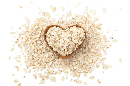 Oat flakes, raw oatmeal in heart shape wooden bowl isolated on white background, top viewの写真素材