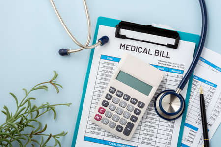 Medical bill concept with calculator and doctor tool on blue backgroundの写真素材
