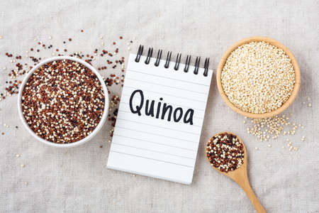 Quinoa word on notebook with red ,white and black quinoa in bowls, top viewの写真素材