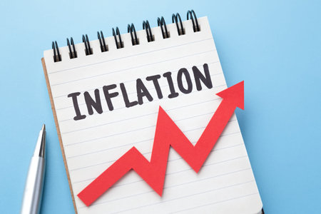 Inflation word on notebook and red graph going up with pen on blue backgroundの写真素材