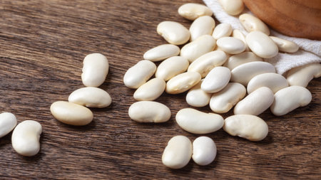 Pile of white beans closeup on wooden table