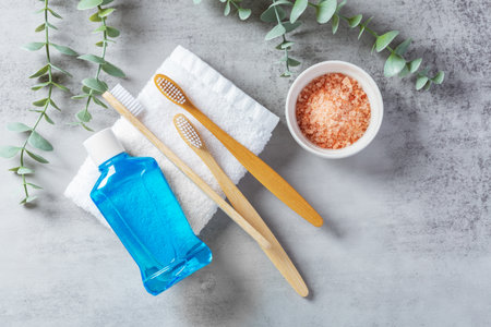 Oral heath care concept, toothbrush with mouthwash on towel and pink salt on cement background, flatlayの写真素材