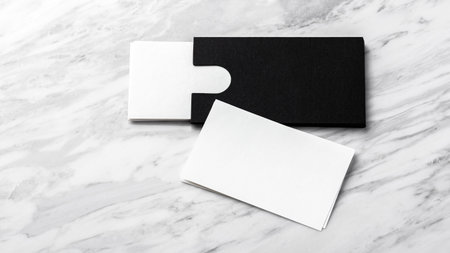Business card mockup with black paper card holder on white marble background