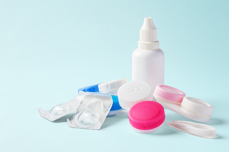 Contact lenses with cases and solution bottle on blue background, copy spaceの写真素材