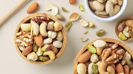 Mixed nuts in wood bowl on beige background, top viewの写真素材