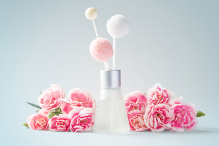 Fragrance diffuser and pink flowers on vintage blue backgroundの写真素材