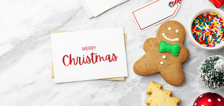 Christmas holiday card and envelope with snowman gingerbread cookie and christmas decor  on marble table, top viewの写真素材