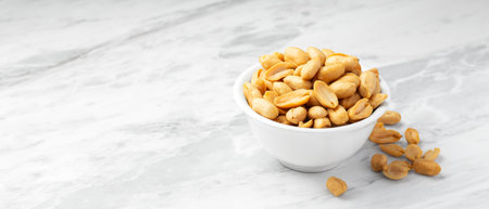 Peanuts in white bowl with wood spoon on marble table background, copy spaceの写真素材