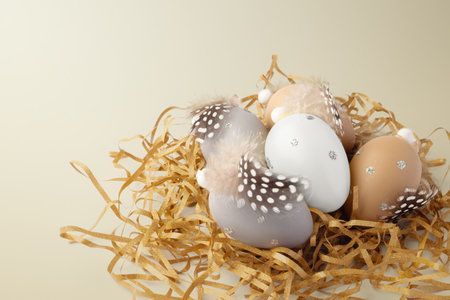 Easter holiday background, easter eggs with feathers decor on gold glitter shredded paper, copy spaceの写真素材