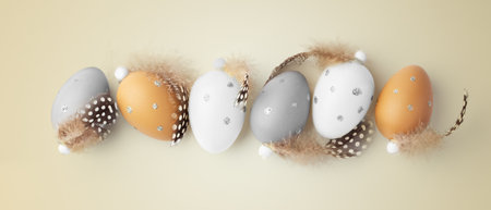 Easter eggs with feathers decor on gold background, easter holiday concept, top viewの写真素材