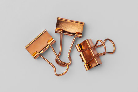 Copper binder clip on grey background, top viewの写真素材
