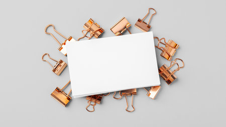 Blank business card mockup on copper binder paper clips on grey backgroundの写真素材