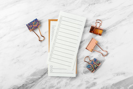 To do list paper with rose gold binder clip on marble table background, top viewの写真素材