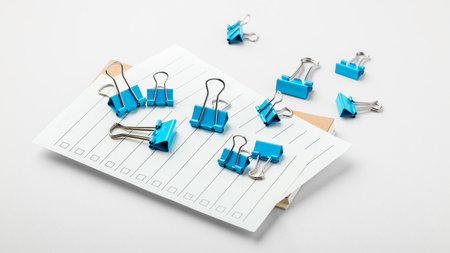 Blue binder clips on checklist paper on grey table backgroundの写真素材