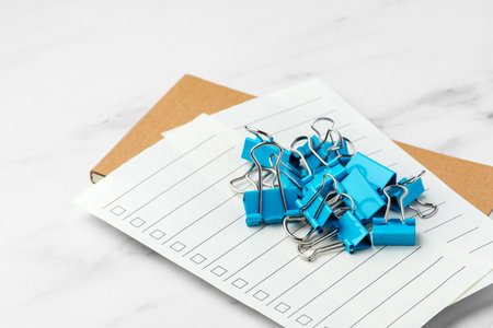 Checklist paper with heap of blue binder clips on marble table backgroundの写真素材