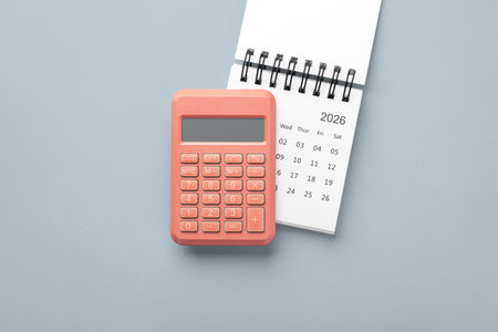Coral calculator on calendar 2026 on gray background, business finance, budget planning, top viewの写真素材