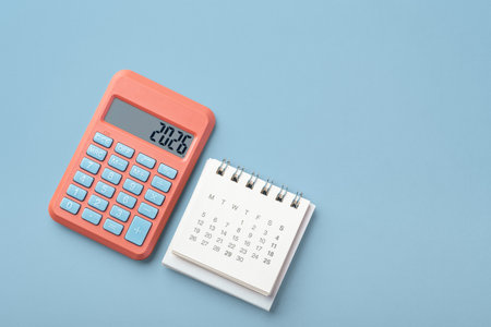 Calculator with 2026 and calendar on blue background, top view, copy spaceの写真素材