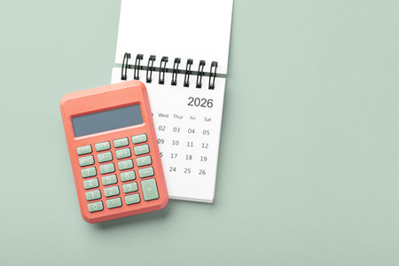 Calculator on calendar 2026 on pastel green background, new year financial resolutions, top view, copy spaceの写真素材
