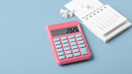 Pink calculator with 2026 and calendar on blue background, tax payment, financial planning conceptの写真素材