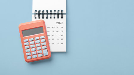 Calculator on calendar 2026 on blue background, business finance, budget planning, top view, copy spaceの写真素材