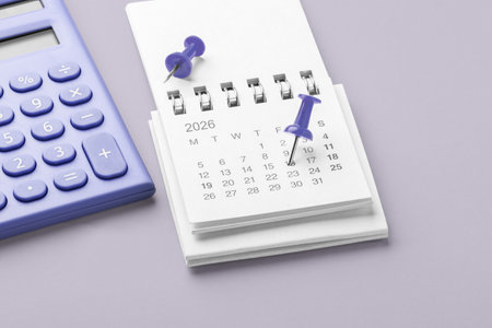 Pinned date on calendar 2026 with calculator on pastel purple background, financial reminder, tax payment, budget planningの写真素材