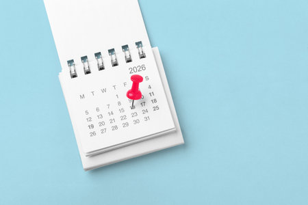 Calendar with pinned date on blue background, business reminder or appointment, holiday planningの写真素材