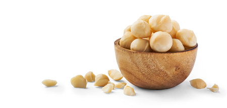 Macadamia nuts in wooden bowl with cracked macadamia isolated on white background, copy spaceの写真素材
