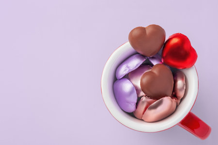 Heart shaped chocolate in red cup on pastel purple background, Valentines day, love concept, top view, copy spaceの写真素材