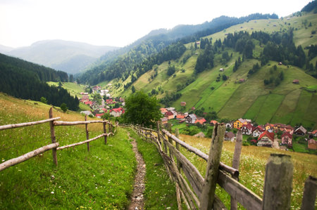 Rural road to village between the hillsの写真素材