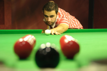 Snooker player potting an easy black ball, but through a 