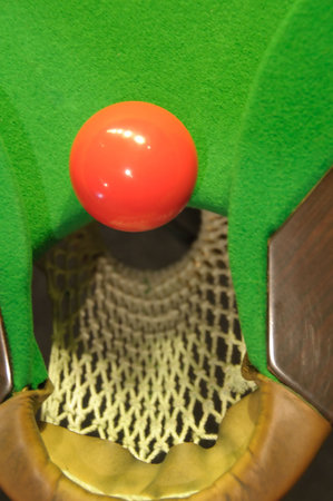 Close-up of red snooker ball near the pocket (view from above)