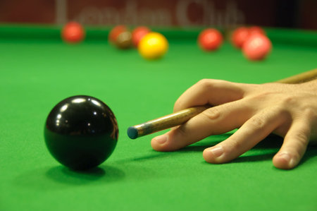 Striking the cue between the fingers (sometimes used for the opening shot at pool)
