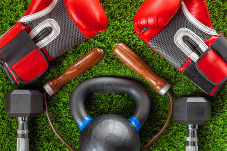 Boxing gloves, skipping rope, dumbbells and weights on the grass.の写真素材