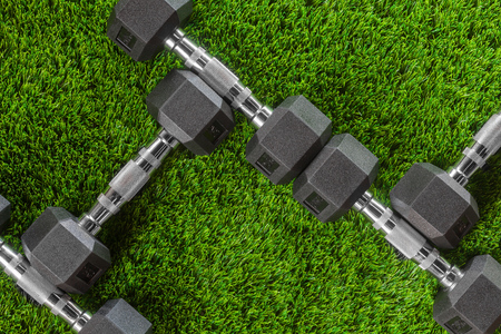 Metal dumbbells on green grass.の写真素材