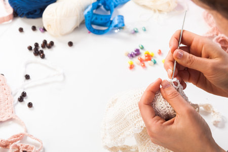 A close-up on top is a table for creativity with knitted things, threads, beads, glasses, ribbons....