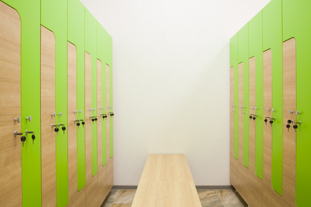Green and wooden sports wardrobe in the gym for clothes and a wooden benchの写真素材