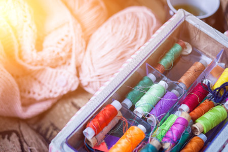 The still life of a tangle of pink woolen threads, an unbound pink sweater and a multitude of coils...