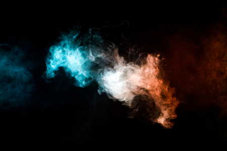 Thick colorful smoke of red and blue on a black isolated background. Background from the smoke of vapeの写真素材