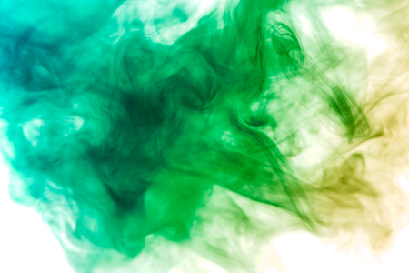 Thick colorful smoke of green on a white isolated background. Background from the smoke of vapeの写真素材