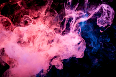 Thick colorful smoke of  pred and  blue on a black isolated background. Background from the smoke of vapeeの写真素材